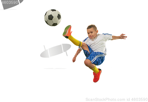 Image of Young boy with soccer ball doing flying kick