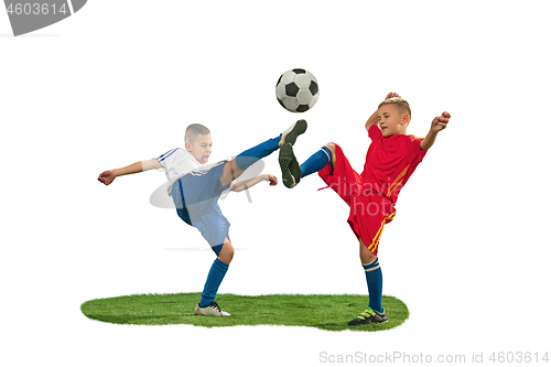 Image of Young boys with soccer ball doing flying kick