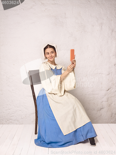 Image of Medieval Woman in Historical Costume Wearing Corset Dress and Bonnet.