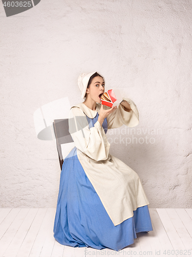 Image of Medieval Woman in Historical Costume Wearing Corset Dress and Bonnet.