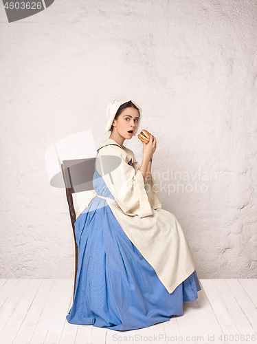 Image of Medieval Woman in Historical Costume Wearing Corset Dress and Bonnet.