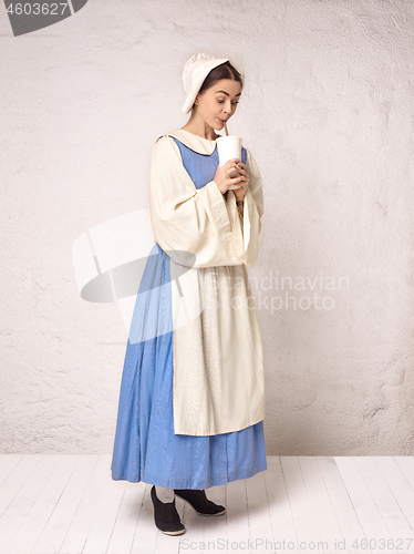 Image of Medieval Woman in Historical Costume Wearing Corset Dress and Bonnet.