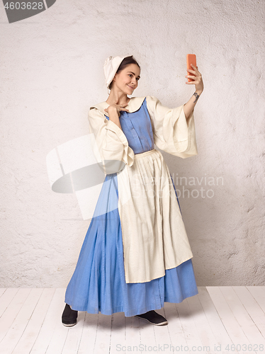 Image of Medieval Woman in Historical Costume Wearing Corset Dress and Bonnet.