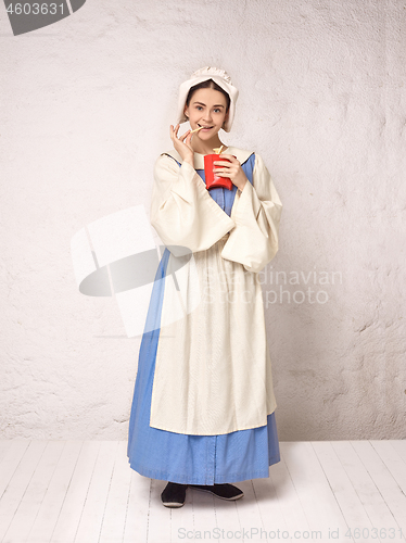 Image of Medieval Woman in Historical Costume Wearing Corset Dress and Bonnet.