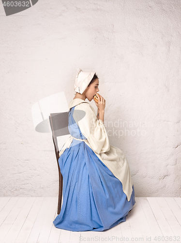 Image of Medieval Woman in Historical Costume Wearing Corset Dress and Bonnet.