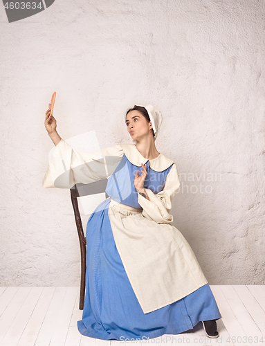 Image of Medieval Woman in Historical Costume Wearing Corset Dress and Bonnet.