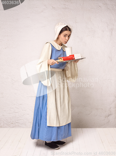 Image of Medieval Woman in Historical Costume Wearing Corset Dress and Bonnet.