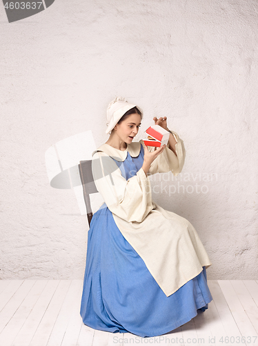 Image of Medieval Woman in Historical Costume Wearing Corset Dress and Bonnet.