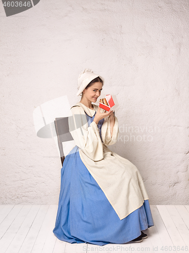 Image of Medieval Woman in Historical Costume Wearing Corset Dress and Bonnet.