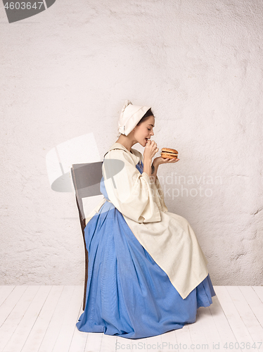 Image of Medieval Woman in Historical Costume Wearing Corset Dress and Bonnet.