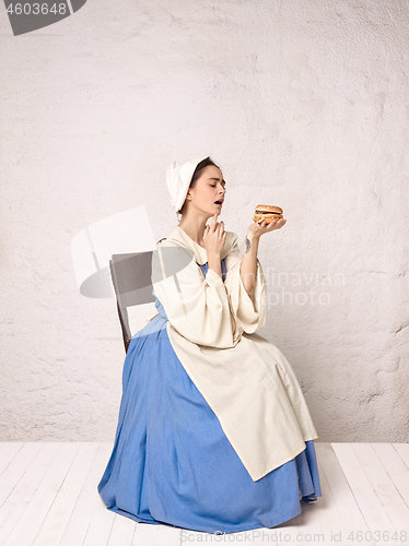 Image of Medieval Woman in Historical Costume Wearing Corset Dress and Bonnet.