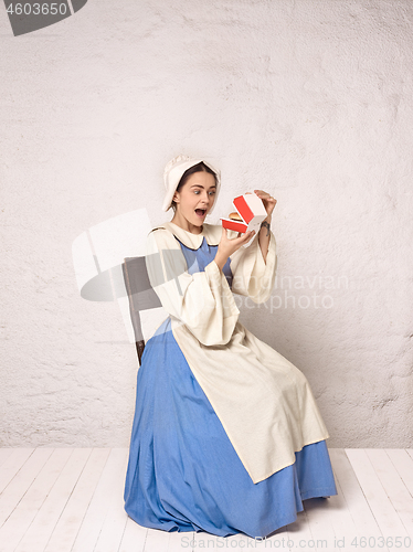 Image of Medieval Woman in Historical Costume Wearing Corset Dress and Bonnet.