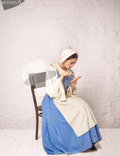 Image of Medieval Woman in Historical Costume Wearing Corset Dress and Bonnet.