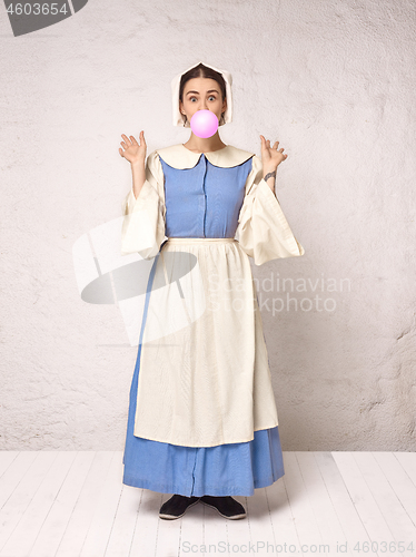 Image of Medieval Woman in Historical Costume Wearing Corset Dress and Bonnet.