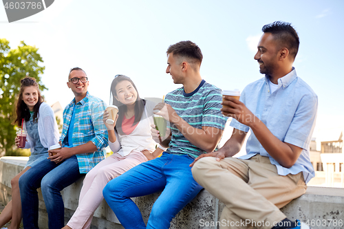 Image of friends drinking coffee and juice talking in city