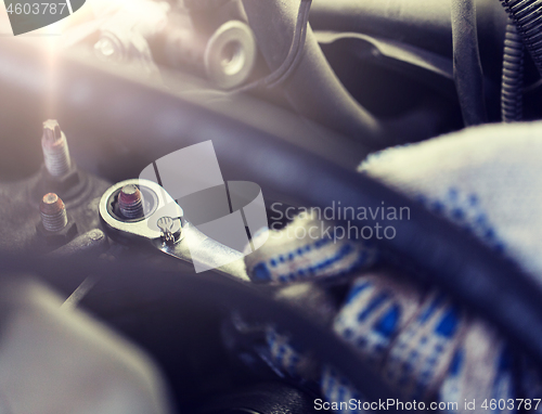 Image of mechanic man with wrench repairing car at workshop