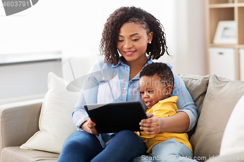 Image of mother using tablet pc with baby son at home