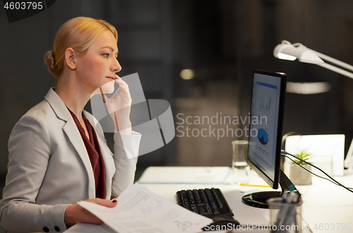 Image of businesswoman calling on smartphone at office