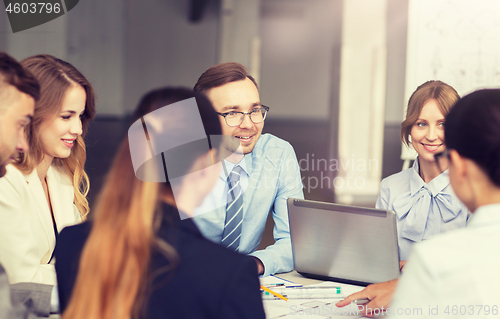 Image of architects with laptop and blueprint at office