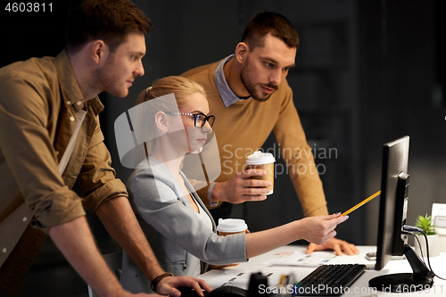 Image of business team with computer working late at office