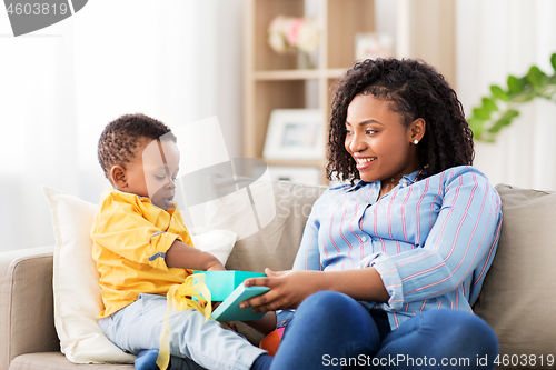 Image of happy mother and baby with open gift box at home