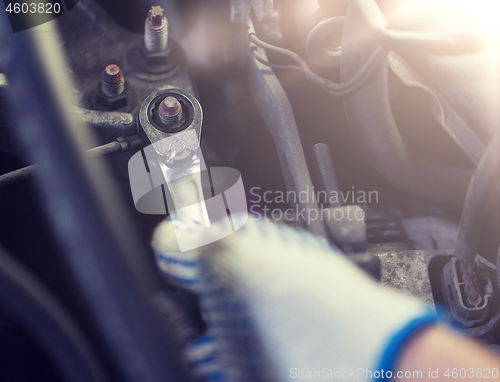 Image of mechanic man with wrench repairing car at workshop