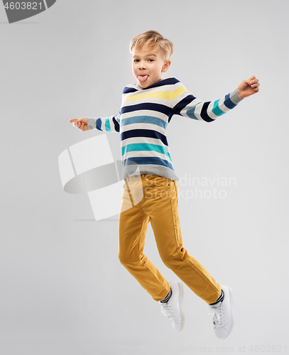 Image of happy little boy jumping and having fun