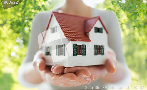 Image of close up of hands holding house or home model