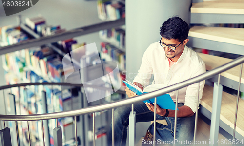 Image of hindu student boy or man reading book at library