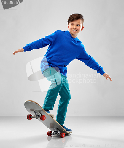 Image of smiling boy in blue hoodie with skateboard