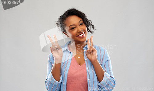 Image of happy african american woman showing peace