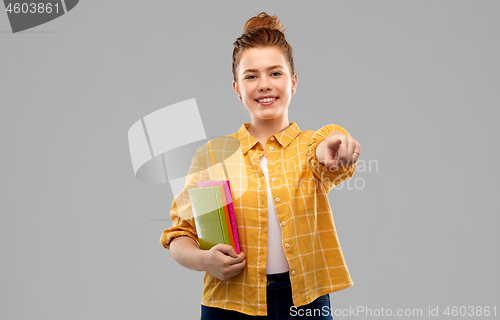 Image of teenage student girl with books pointing to you