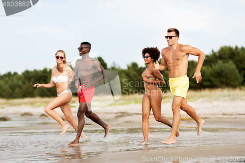 Image of happy friends running on summer beach