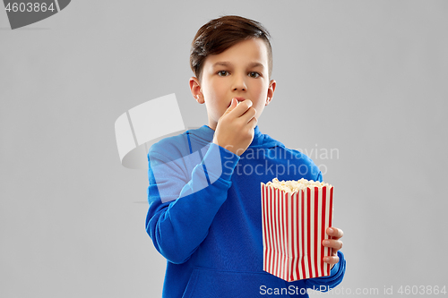 Image of boy in blue hoodie eating popcorn