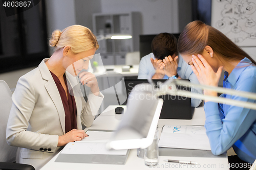 Image of business team with laptop working late at office