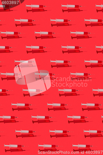 Image of Medicinal pattern of flying syringes with red blood or vaccine.