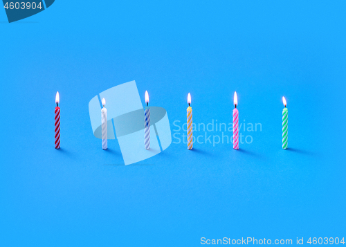 Image of Light burning vertical candles for sweet dessert and cakes.