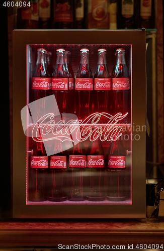 Image of Bottles of Coca Cola in a fridge with logo