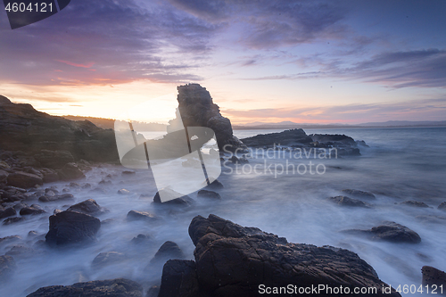 Image of Sun setting behind the cave arch rock