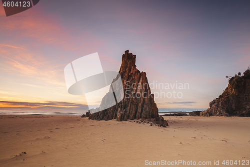 Image of Pyramid sea stack on beach with beautiful sunrise sky with red c