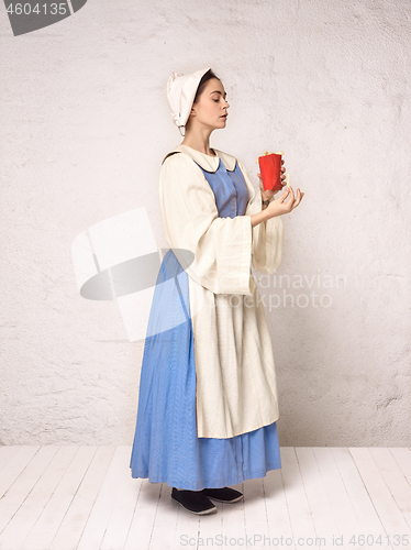 Image of Medieval Woman in Historical Costume Wearing Corset Dress and Bonnet.