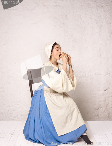 Image of Medieval Woman in Historical Costume Wearing Corset Dress and Bonnet.