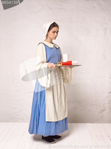 Image of Medieval Woman in Historical Costume Wearing Corset Dress and Bonnet.