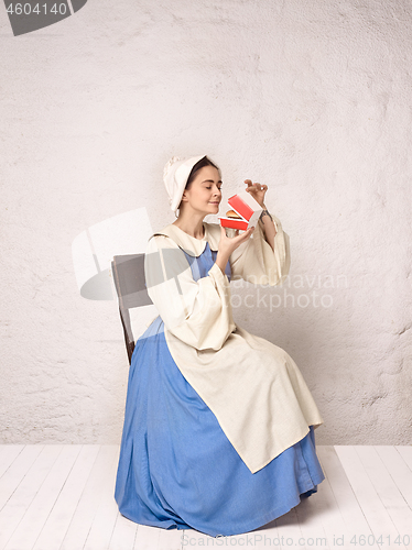 Image of Medieval Woman in Historical Costume Wearing Corset Dress and Bonnet.