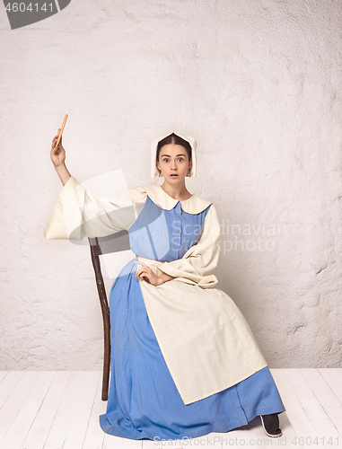 Image of Medieval Woman in Historical Costume Wearing Corset Dress and Bonnet.