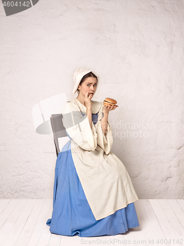 Image of Medieval Woman in Historical Costume Wearing Corset Dress and Bonnet.