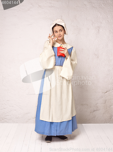 Image of Medieval Woman in Historical Costume Wearing Corset Dress and Bonnet.