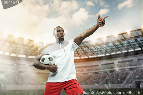 Image of The football player in motion on the field of stadium