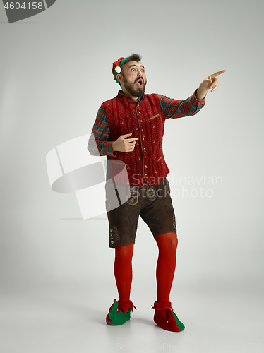 Image of friendly man dressed like a funny gnome posing on an isolated gray background