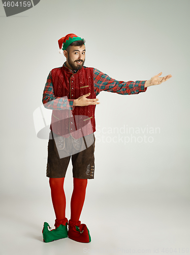 Image of friendly man dressed like a funny gnome posing on an isolated gray background